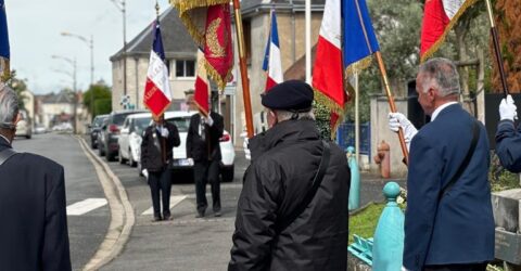 photo de la cérémonie du 18 juin, en 2024. Au premier plan les portes drapeaux à côté du monument aux morts